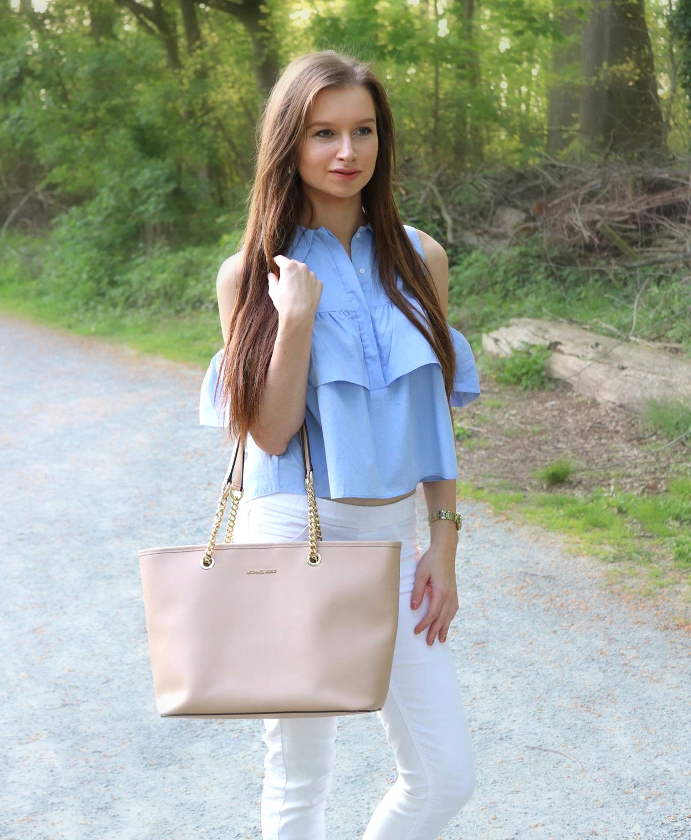 Blue ruffled blouse with white jeans and Michael Kors bag